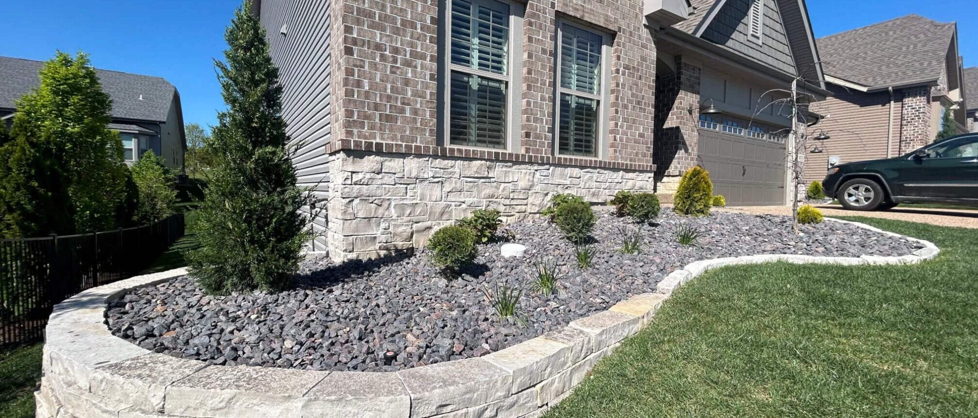 Modern brick home with retaining wall and modern landscaping