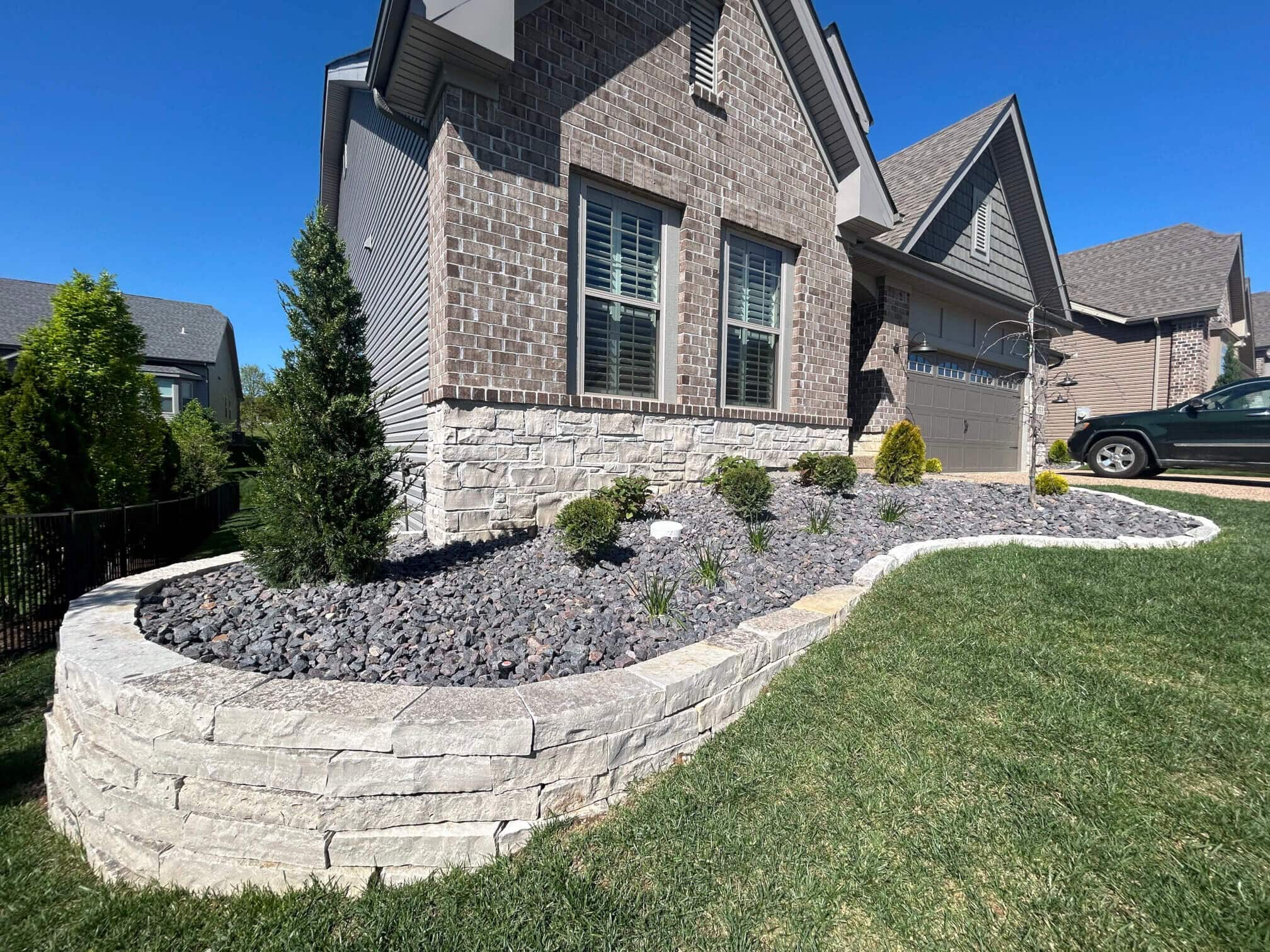 Modern brick home with retaining wall and modern landscaping