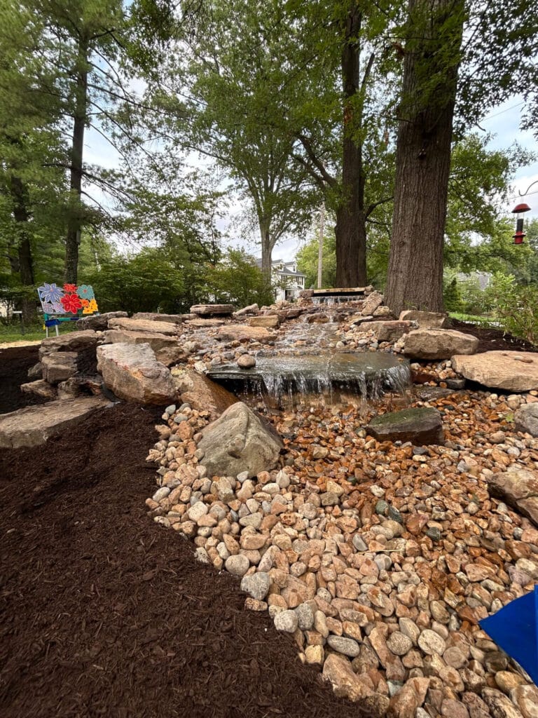 Stone Waterfall Feature Surrounded by Natural Stone Decorative Rock