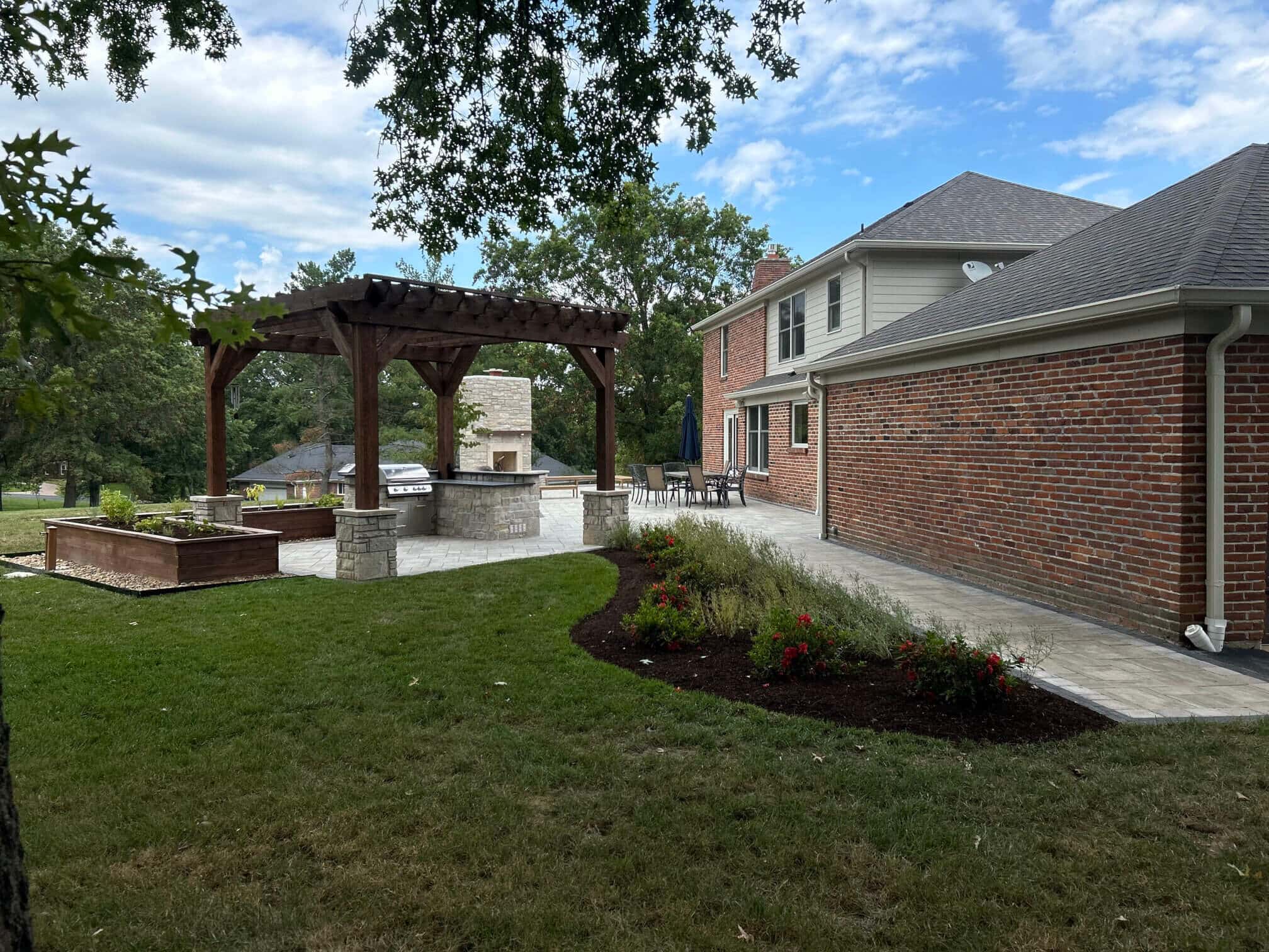 Brick home with modern landscaping and a pergola and outdoor living space